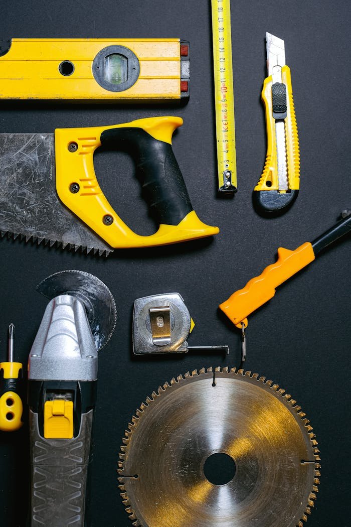 why-choose-us A collection of yellow and black construction tools arranged on a dark flat surface, ideal for DIY projects.